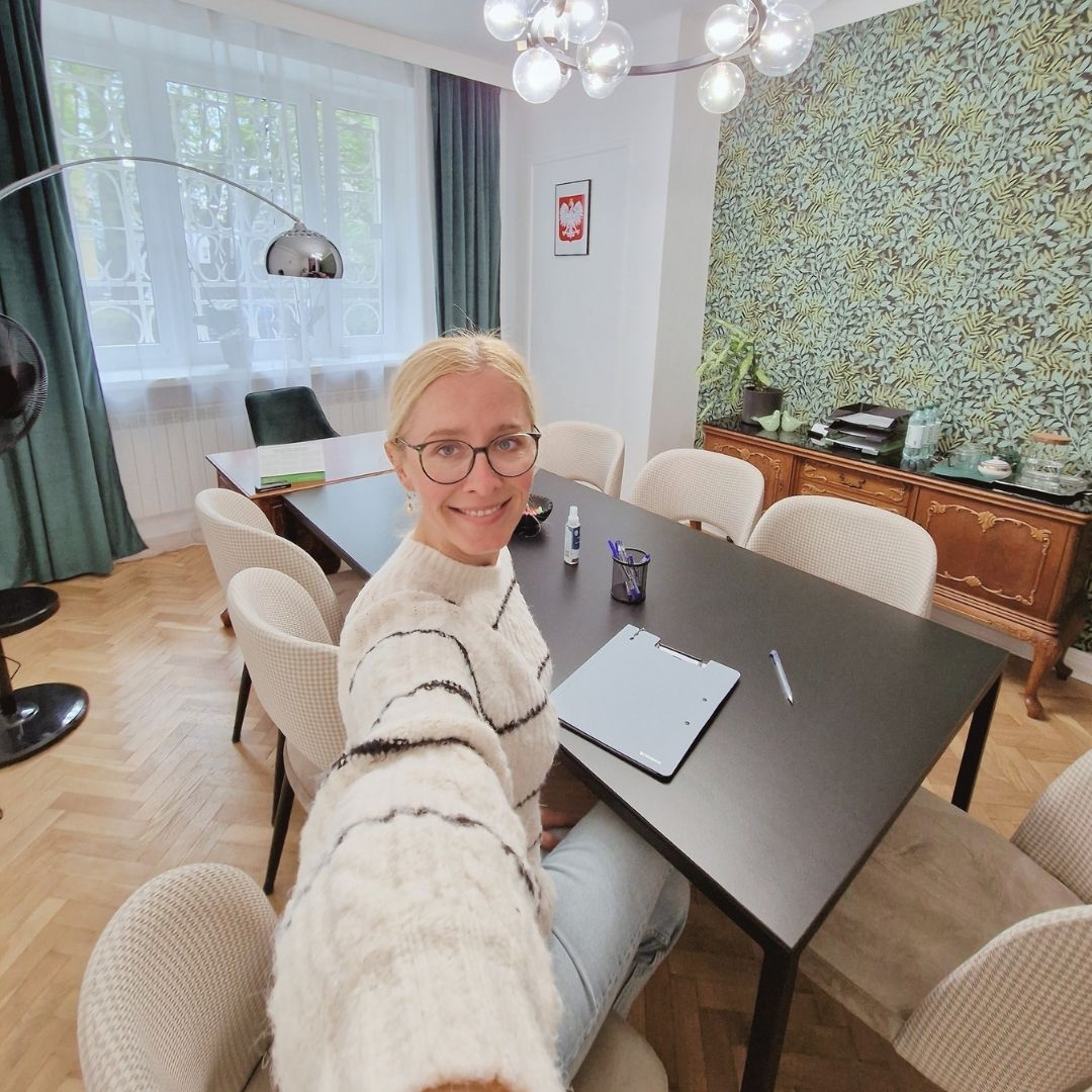 Kobieta podczas spotkania przy stole w sali fundacji.